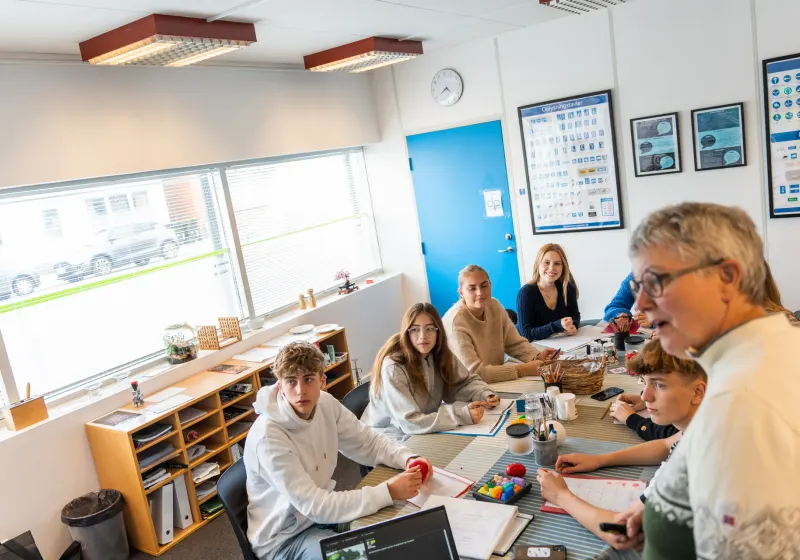 Libber og elever sidder omkring bordet i teorilokalet