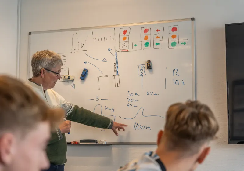 Libber forklarer trafikregler ved tavlen