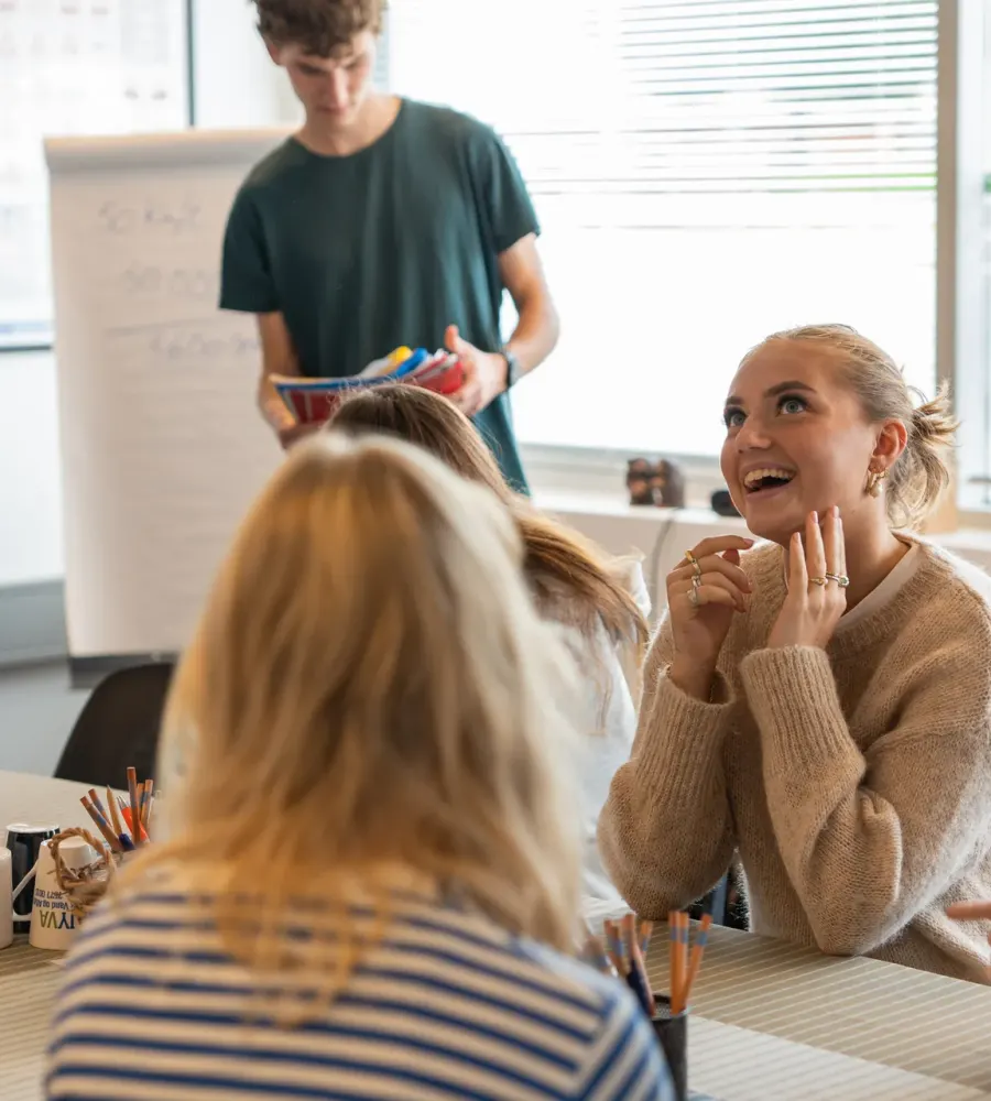 Elever griner sammen i teorilokalet